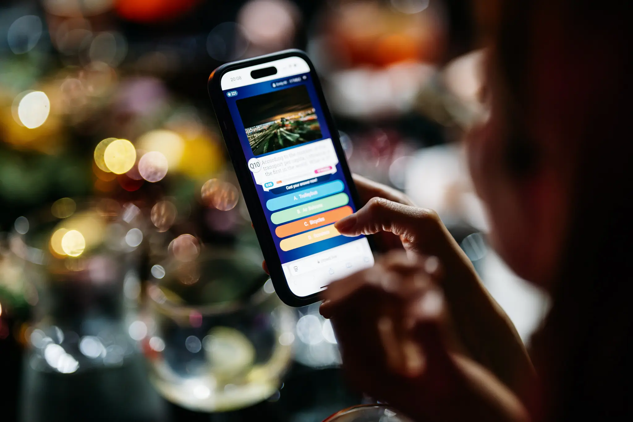Dalyvis telefone atsako į interaktyvaus protmūšio klausimą